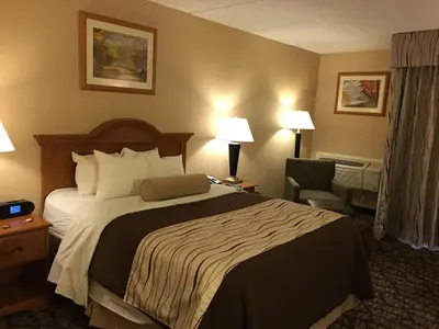 a hotel room with a bed and a chair at Best Western Clifton Park in Clifton Park
