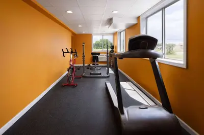 a gym with two treadmills and exercise bikes at Days Inn by Wyndham Queensbury/Lake George in Queensbury