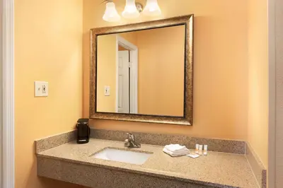 a bathroom with a sink and a mirror at Days Inn by Wyndham Queensbury/Lake George in Queensbury