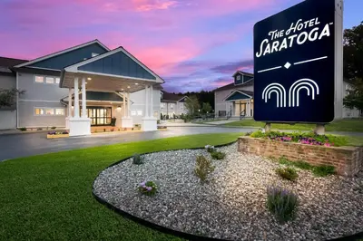 a sign in front of a house with a building at The Hotel Saratoga, an Ascend Collection Hotel in Saratoga Springs