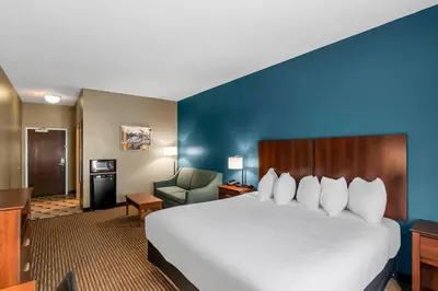 a hotel room with a large bed and a chair at The Hotel Saratoga, an Ascend Collection Hotel in Saratoga Springs