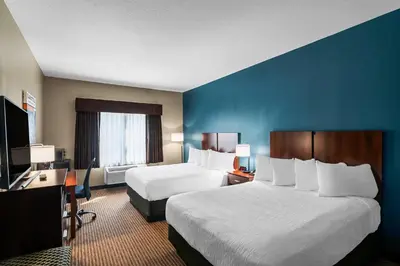 a hotel room with two beds and a television at The Hotel Saratoga, an Ascend Collection Hotel in Saratoga Springs