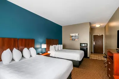 a hotel room with two beds and a television at The Hotel Saratoga, an Ascend Collection Hotel in Saratoga Springs