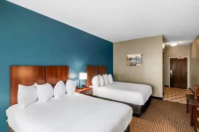 a hotel room with two beds and a blue wall at The Hotel Saratoga, an Ascend Collection Hotel in Saratoga Springs
