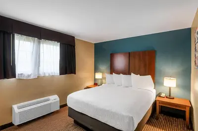 a hotel room with a large bed and two lamps at The Hotel Saratoga, an Ascend Collection Hotel in Saratoga Springs