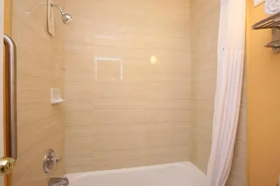 a bathroom with a shower with a tub at BLUE SKY INN Glens Falls-Saratoga-Lake George in Glens Falls