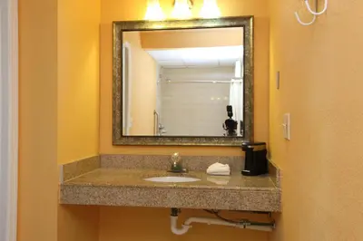 a bathroom with a sink and a mirror at BLUE SKY INN Glens Falls-Saratoga-Lake George in Glens Falls