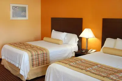 a hotel room with two beds and a phone at BLUE SKY INN Glens Falls-Saratoga-Lake George in Glens Falls
