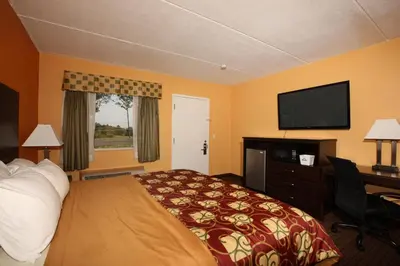 a hotel room with a bed and a flat screen tv at BLUE SKY INN Glens Falls-Saratoga-Lake George in Glens Falls