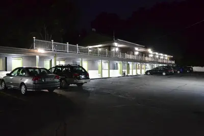a building with cars parked in a parking lot at night at Mount Holyoke Inn in Holyoke