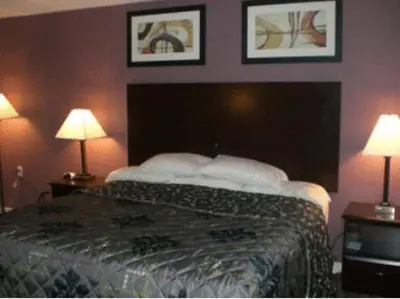 a bedroom with a bed with two lamps and a tv at Mount Holyoke Inn in Holyoke