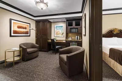 a hotel room with a bed and chairs and a desk at Hotel Lucerne in New York