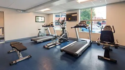 a gym with several treadmills and cardio machines at Best Western PLUS Franklin Square Inn in Troy