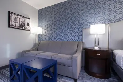 a living room with a couch and a chair and a table at Best Western PLUS Franklin Square Inn in Troy