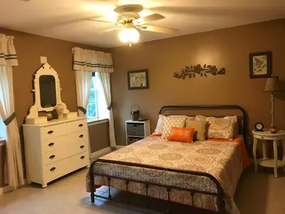a bedroom with a bed with a dresser and a mirror at Coolis Apartment in Richfield Springs