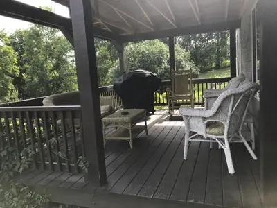a wooden deck with chairs and a bench on it at Coolis Apartment in Richfield Springs