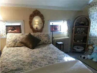 a bedroom with a large bed and a mirror at A Meadow House in Lakeville