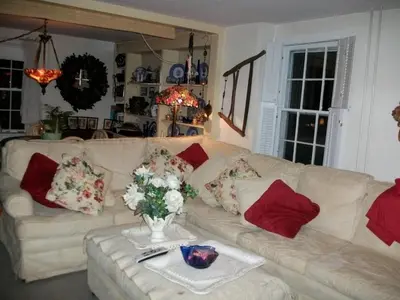 a living room with a white couch with red pillows at A Meadow House in Lakeville