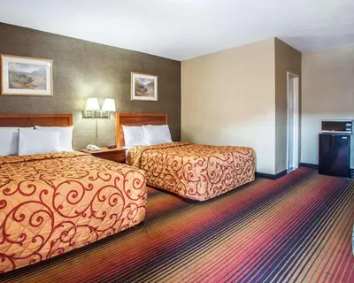 a hotel room with two beds and a television at Rodeway Inn Jersey City North in Jersey City