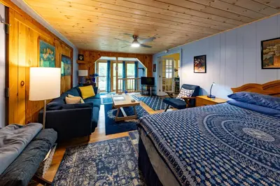 a bedroom with a bed and a living room at Cavalier Cottage B&B in Shelburne Falls