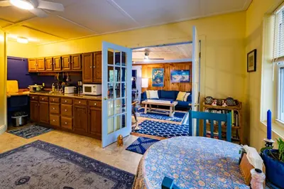 a kitchen with a door open to a living room at Cavalier Cottage B&B in Shelburne Falls