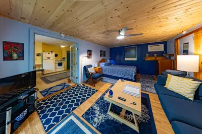 a living room with blue walls and a blue couch at Cavalier Cottage B&B in Shelburne Falls