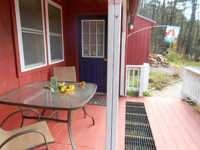 a table on the porch of a red house at Cavalier Cottage B&B in Shelburne Falls