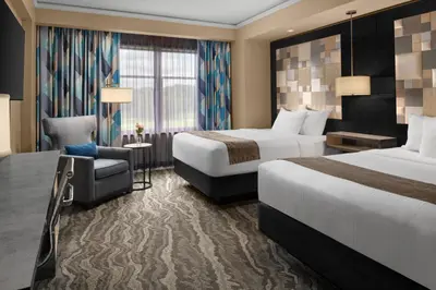 a hotel room with two beds and a chair at Mount Airy Casino Resort - Adults Only 21 Plus in Mount Pocono