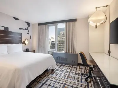 a hotel room with a bed and a large window at Hilton New York Fashion District in New York