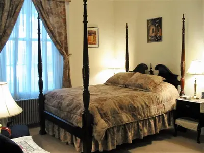 a bedroom with a four poster bed and a window at The Historic Mansion in New Haven
