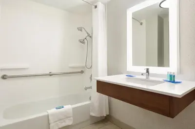 a bathroom with a sink and a tub and a mirror at Holiday Inn Express Hartford South - Rocky Hill by IHG in Rocky Hill