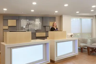 a woman standing at a podium in a room with two blank signs at Holiday Inn Express Hartford South - Rocky Hill by IHG in Rocky Hill