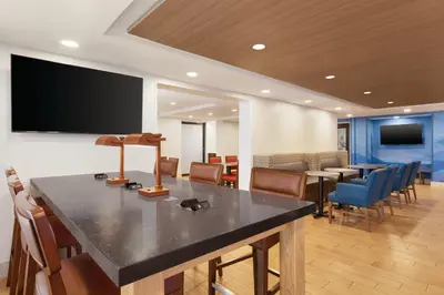 a conference room with tables and chairs and a flat screen tv at Holiday Inn Express Hartford South - Rocky Hill by IHG in Rocky Hill