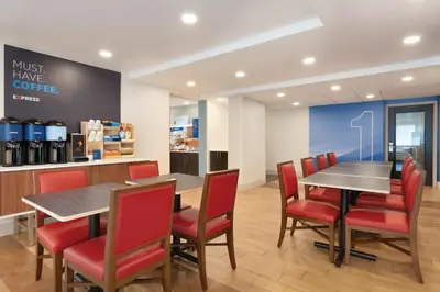 a dining room with a table and red chairs at Holiday Inn Express Hartford South - Rocky Hill by IHG in Rocky Hill