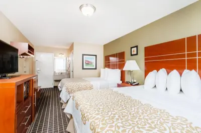 a hotel room with two beds and a flat screen tv at Days Inn by Wyndham Windsor Locks / Bradley Intl Airport in Windsor Locks