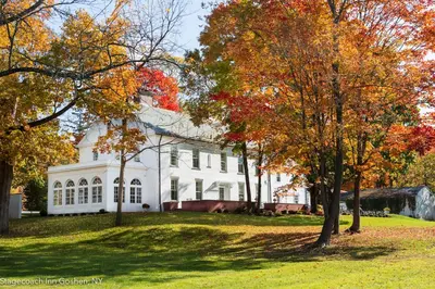 a white house with trees in front of it at Stagecoach Inn in Goshen