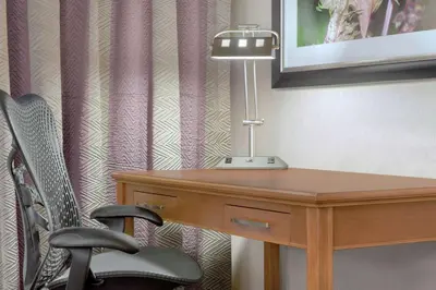 a desk with a lamp and a chair in a room at Hilton Garden Inn Springfield, MA in Springfield
