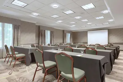 a conference room with tables and chairs and a whiteboard at Hilton Garden Inn Springfield, MA in Springfield