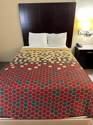 a bed in a hotel room with a colorful bedspread at Econo Lodge Scranton near Montage Mountain in Scranton