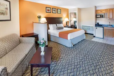 a hotel room with a bed and a kitchen at Howard Johnson by Wyndham Lenox in Lenox