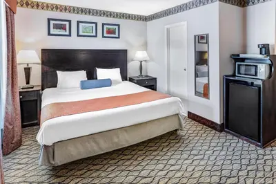 a hotel room with a large bed and a microwave at Howard Johnson by Wyndham Lenox in Lenox