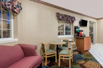 a living room with a couch and a table and chairs at Howard Johnson by Wyndham Lenox in Lenox