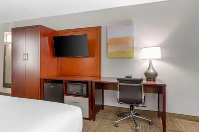 a hotel room with a desk with a bed and a television at Comfort Inn Edgewater on Hudson River in Edgewater