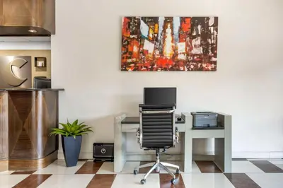an office with a desk with a computer and a painting at Comfort Inn Edgewater on Hudson River in Edgewater