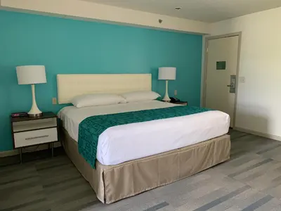 a bedroom with a large bed with a blue wall at Howard Johnson by Wyndham Williamstown in Williamstown