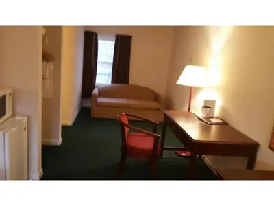 a hotel room with a desk and a chair at Howard Johnson by Wyndham Williamstown in Williamstown