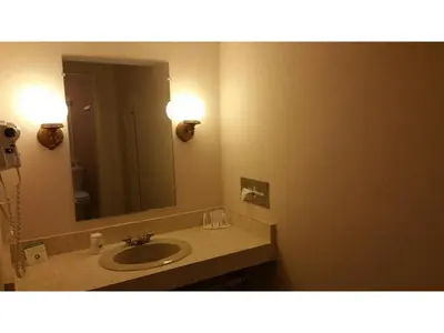 a bathroom with a sink and a large mirror at Howard Johnson by Wyndham Williamstown in Williamstown