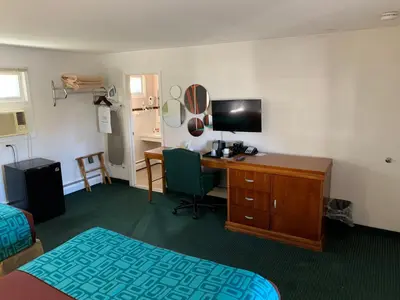 a hotel room with a desk and a bed and a computer at Howard Johnson by Wyndham Williamstown in Williamstown