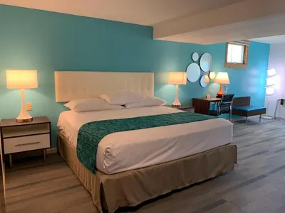 a bedroom with a large bed with blue walls at Howard Johnson by Wyndham Williamstown in Williamstown