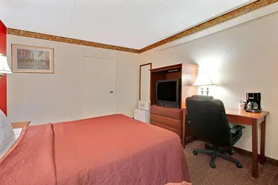 a hotel room with a bed and a desk and a computer at TraveIodge by Wyndham Parsippany in Parsippany